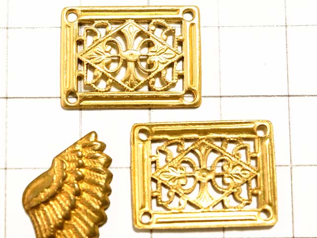 MF626JJ　フィリグリー　長方形　４穴　真鍮<br>四隅にホール穴がある、端正なメタルパーツ。<br>コネクターやシャンデリアパーツとしても使えそうです。<br><br>画像のマス目は１ｃｍ四方です。大きさの目安にして下さい。真鍮スタンピングは色合いの目安にどうぞ。<br>１４．８ｍｍ×２０ｍｍ　高さ　１．２ｍｍ<br>